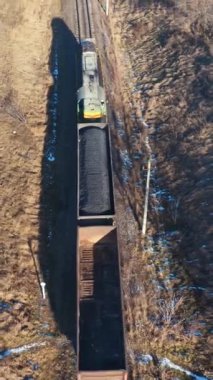 Tren yukarıdan trenle geliyor. Demiryolu üzerindeki trenin hava manzarası kırsal kesimden geçiyor.