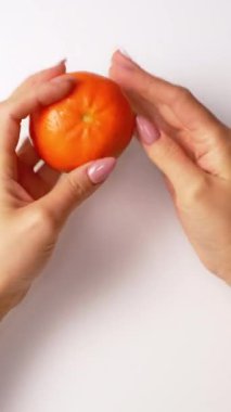 Eller mandalinayı tutuyor. Mandalina tutan kadın ellerine yakın çekim