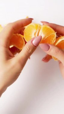 Kadın ellerinde soyulmuş mandalina. Beyaz arkaplanda Mandarin 'i kapat