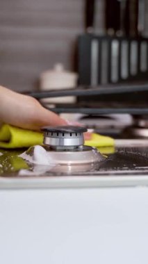 El temizleme fırını. Mutfaktaki gaz sobasını temizleyen kadın elini kapat.