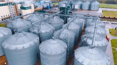 Tarım ürünlerini depolamak için iki büyük metal tank grubu. Kırsal bölgedeki tarım işletmesinin üstündeki görüntüler..