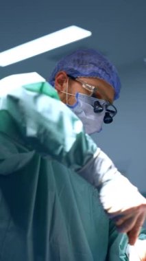 Kafkas cerrahı ameliyatta tornavida kullanır. Ameliyathanede çalışan doktorun görüş açısı düşük. Dikey video.
