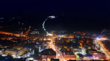 Geceleri kış kasabasının muhteşem aydınlanması. Noel 'de Polonya' nın Zakopane şehrinde insansız hava aracı uçuşu.