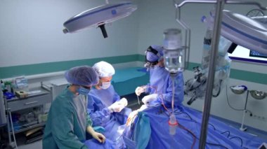 Kafkas cerrahları beyin ameliyatı yapıyor. Ameliyat hemşiresi beyin cerrahları için alet ve malzeme hazırlıyor. Yüksek açı görünümü.