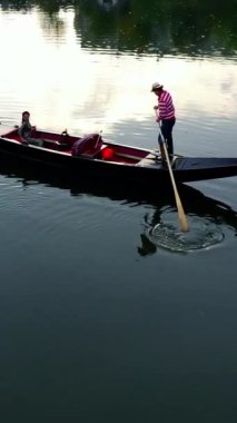 Gondollu şehir nehri. Şehir nehrinde gondolla gezen turistler