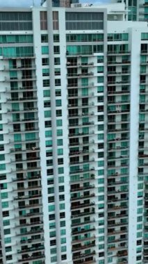 Konut bölgesinde çok katlı yüksek binalar. Miami şehir merkezindeki apartman bloğu. Dikey video