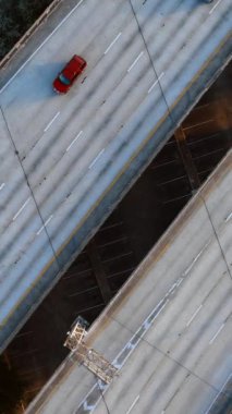 Arabalar her iki tarafa giden otobandaki çok şeritli yoldan gider. Suyun üstündeki yarış pistinin üst görüntüsü. Dikey video