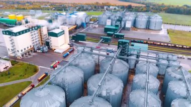 Tahıl kurutmak için metal varil gruplarıyla endüstriyel tarım girişimi. Dolu trenli demiryolları tesisin bölgesinden geçiyor. Hava görünümü.