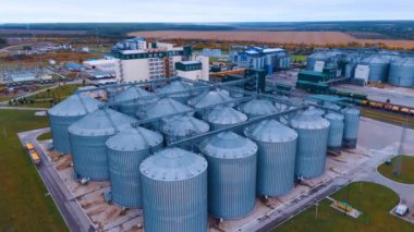 Zirai ürünlerin işlenmesi, kurutulması, temizlenmesi ve depolanması için tarım ve imalat tesisinde metal silolar. Kırsal kesimdeki işletmeye hava perspektifi.