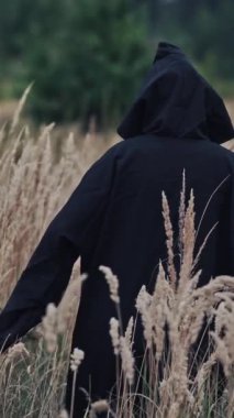 Dışarıdaki korkunç cadı. Siyah cüppeli korkunç bir hayalet ve kafasında korkunç bir yüz olan bir başlık. Olgun buğday tarlasında ölüm iblisi. Gizemli bir kavram. Dikey video