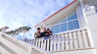 Küçük bebeğiyle güzel beyaz anne-babalar kışın dışarıda olurlar. Mutlu aile birlikte güneşli bir günün tadını çıkarır. Düşük açı görünümü.