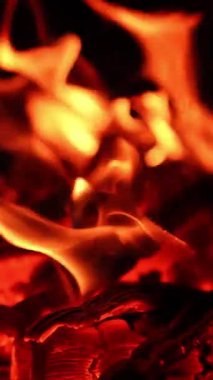 Odun yakmak için sıcak bir yer. Şömineye yakın alevler parlıyor. Dikey video