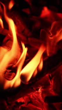 Karanlık gece manzaralı şömine. Kırmızı alevli kamp ateşi parlıyor. Dikey video