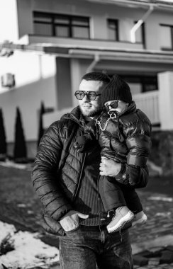 İnsan ve çocuk karda yürür. Karlı bir sokakta yürürken kışın çocuk taşıyan bir adam, soğuk bir günün tadını çıkarıyor..