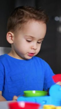 Küçük çocuk için oyun eğitimi. Küçük çocuk renkli oyuncaklarla oynuyor. Dikey video