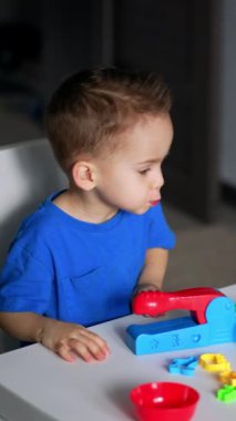 Küçük çocuk renkli oyuncaklarla oynuyor. Küçük çocuk için oyun eğitimi. Dikey video