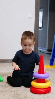 Çocuklar için küçük bir oyun alanı. Yürüyen komik aktif çocuk oyuncaklarla oynuyor. Dikey video