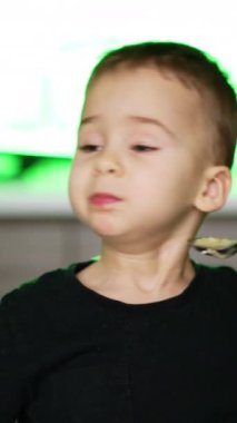 Küçük çocuk yemek istemiyor. Tatlı çocuk çorba içmekten nefret eder. Dikey video
