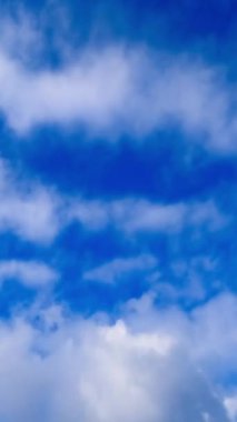 Üzerinde bulutlar akan mavi gökyüzü. Kabarık bulutların hareket zamanı. Dikey video