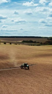 Modern tarım teknolojisi. Traktörün hava görüntüsü kimyasalları geniş alana püskürtüyor.