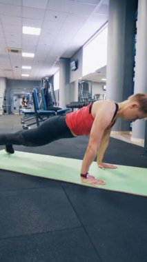 Paspas üzerinde egzersiz yapan genç bir bayan. Fitness modeli spor salonunda minder üzerinde çalışıyor.