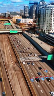 Atlanta, Georgia, ABD 'nin geniş yollarında birden fazla araç hareket ediyor. Şehir merkezinin güneşli gündüz manzarası. Dikey video
