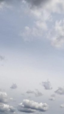 Gri gökyüzü ve ayrı bulutlar. Düşük açıdan kasvetli bulutlu bir manzara. Zaman ayarlı. Dikey video