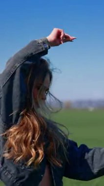 Mikrofonun yanında güzel bir kız. Sahada dans eden ve mikrofona şarkı söyleyen genç bir bayan şarkıcı kameraya bakıyor. Dikey video