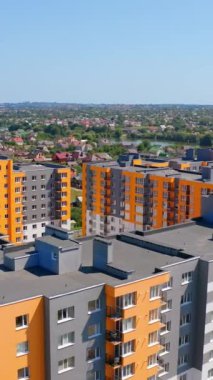 Modern apartman kompleksi. Parlak yüzlü, yüksek binalar. Kalacak yer ve şehirleşme kavramı. Hava görüntüsü. Dikey video