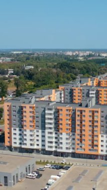 Yeni konut inşaatı. Şehrin kenar mahallelerinde inşa edilmiş apartmanların modern kompleksi. Apartman daireleri. Hava görüntüsü. Dikey video