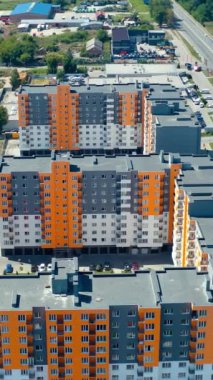 Yukarıdan yeni yerleşim yeri. Şehir sakinleri için park yerleri olan çok katlı binalar. Hava görüntüsü. Dikey video