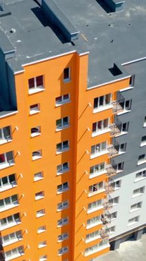 Renkli duvarları olan apartmanlar. Modern apartman daireleri. Şehir sakinleri için yeni yapılmış apartman blokları. Yukarıdan bak. Dikey video