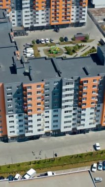 Yeni modern apartman. Şehirdeki çok katlı mimari. Yeni şehir konutları. Bir apartman bloğu. Hava görüntüsü. Üstü açık. Dikey video