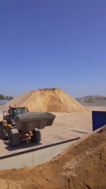 Yeni asfalt yapmak için açık hava bitkisi. Kazıcı karışık asfalt döküyor. Gündüzleri arka plan üretiyorum. Dikey video