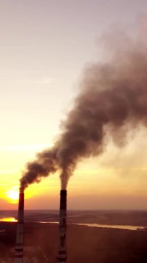 Atmosferi kirletiyor. İki fabrika borusu kirli emisyon fırlatıyor. Duman güzel görünüyor ama günbatımında tehlikeli. Akşamları güzel manzarada elektrik santrali. Dikey video