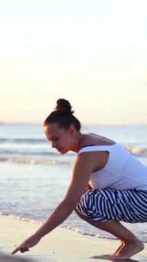 Plajda Dinlenen Kadın. Kumsalda genç ve güzel bir kadının kumlara çizimi.