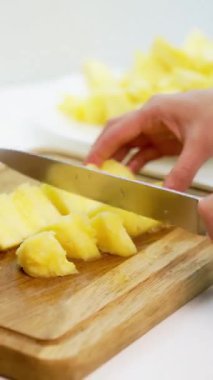 Lezzetli kesilmiş ananaslı bir masa. Beyaz arka planda taze olgun ananaslı kompozisyon