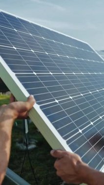 Dışarıda güneş panelleri kuran işçiler. Erkek teknisyenler fotovoltaik güneş panelleri kuruyorlar