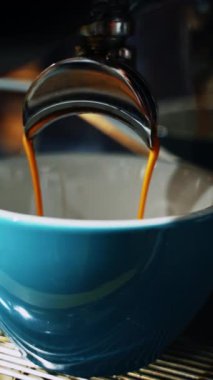Barista kafede kahve yapar. Barista, müşteriye kafede kahve hazırlıyor.