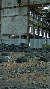 Adam yıkım binasına karşı duruyor. Genç adam eski binaya karşı poz veriyor.