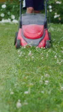 Çimleri biçen çocuk. Yakın plan. Dikey video
