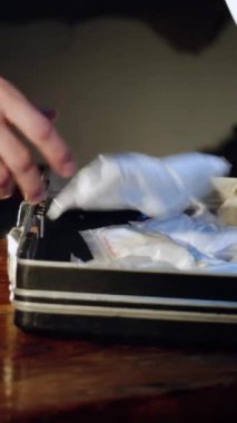 Bir uyuşturucu satıcısı çantasında para ve silahla uyuşturucu paketleri taşıyor. Şu anda polis odaya giriyor ve uyuşturucu satıcısına kelepçe takıyor. Uyuşturucu kaçakçılığı. Dikey video