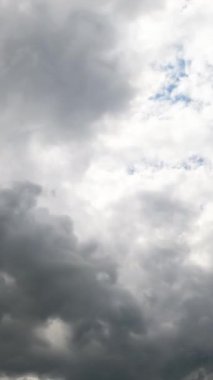 Yoğun bulutlu dramatik gri gökyüzü. Yağmur bulutları atmosferde birikiyor. Düşük açı. Zaman ayarlı. Dikey video