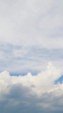 Atmosferdeki iki farklı bulut türünün birleşimi. Kümülüs bulutları sirrus bulutlarına kadar yükselir. Zaman ayarlı. Dikey video