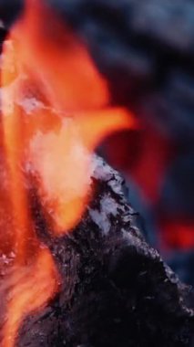 Ahşap külle yanıyor. Yakın çekim ahşap ve hafif turuncu alevle kömür. Ağır çekim. Dikey video