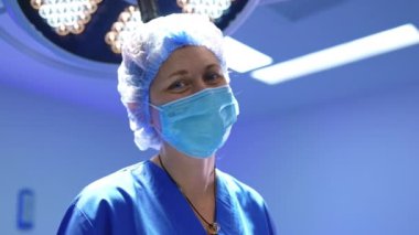 Maskeli ve şapkalı kadın cerrahın güler yüzlü gözleri. Ameliyathanede çalışan bir doktorun portresi..