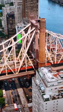 Hudson Nehri üzerindeki Queensboro Köprüsü 'nün desteği. Köprünün altındaki New York yollarından birden fazla araba geçiyor. Üst Manzara. Dikey video