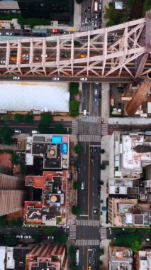 Hudson Nehri 'nin yukarısındaki Queensboro Köprüsü' ne çok sayıda araba girip çıkıyor. New York bölgesinin hava manzarası. Dikey video