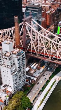 Queensboro Köprüsü 'nün rıhtım tarafı havadan görünüyor. Köprü boyunca ve altında bir sürü araba hareket ediyor. Dikey video