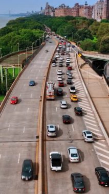 Şehir merkezindeki New York rıhtımı boyunca otoban. Yolun bir tarafında yoğun bir trafik var. Üst Manzara. Dikey video